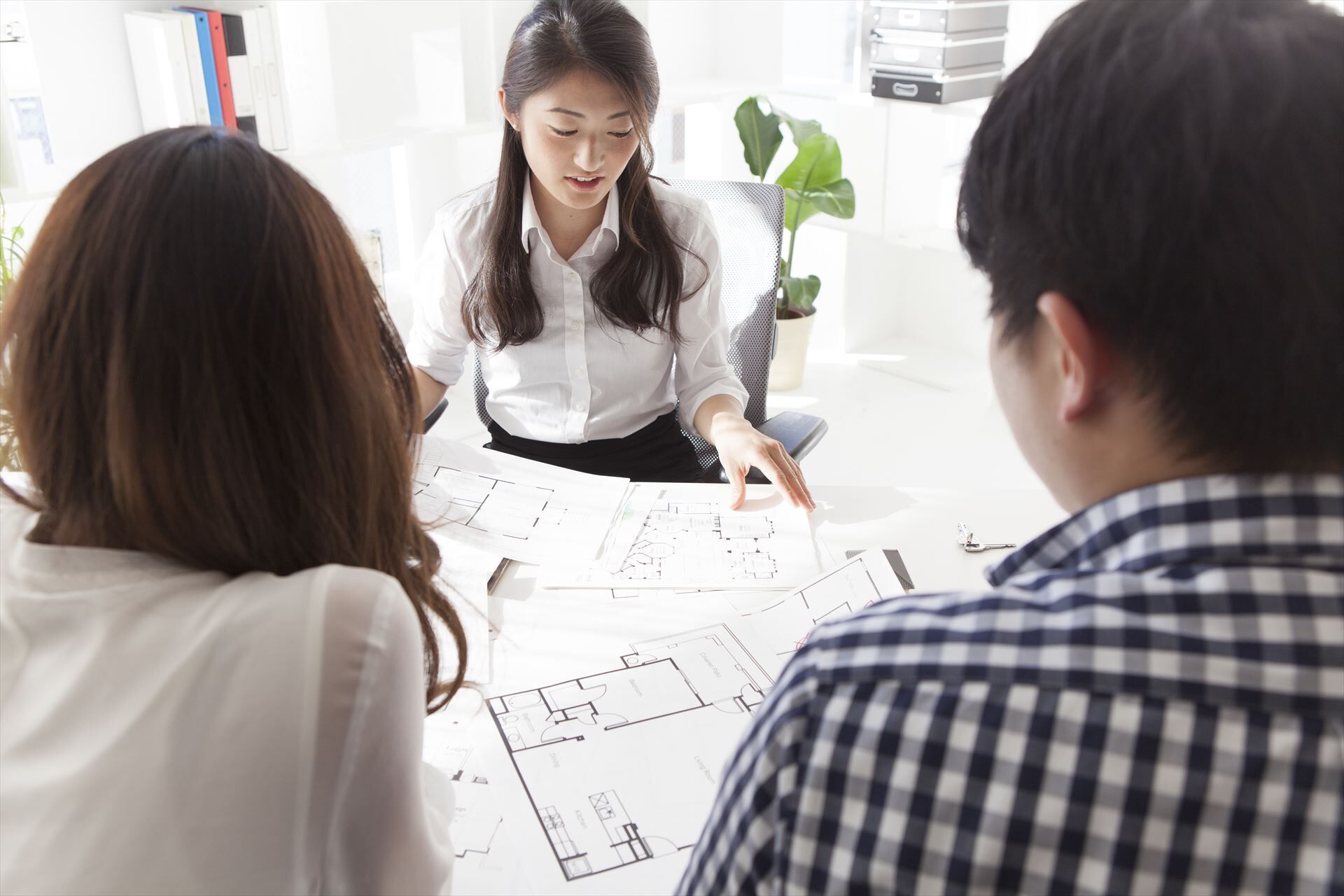 間取り図を見て説明する女性スタッフ
